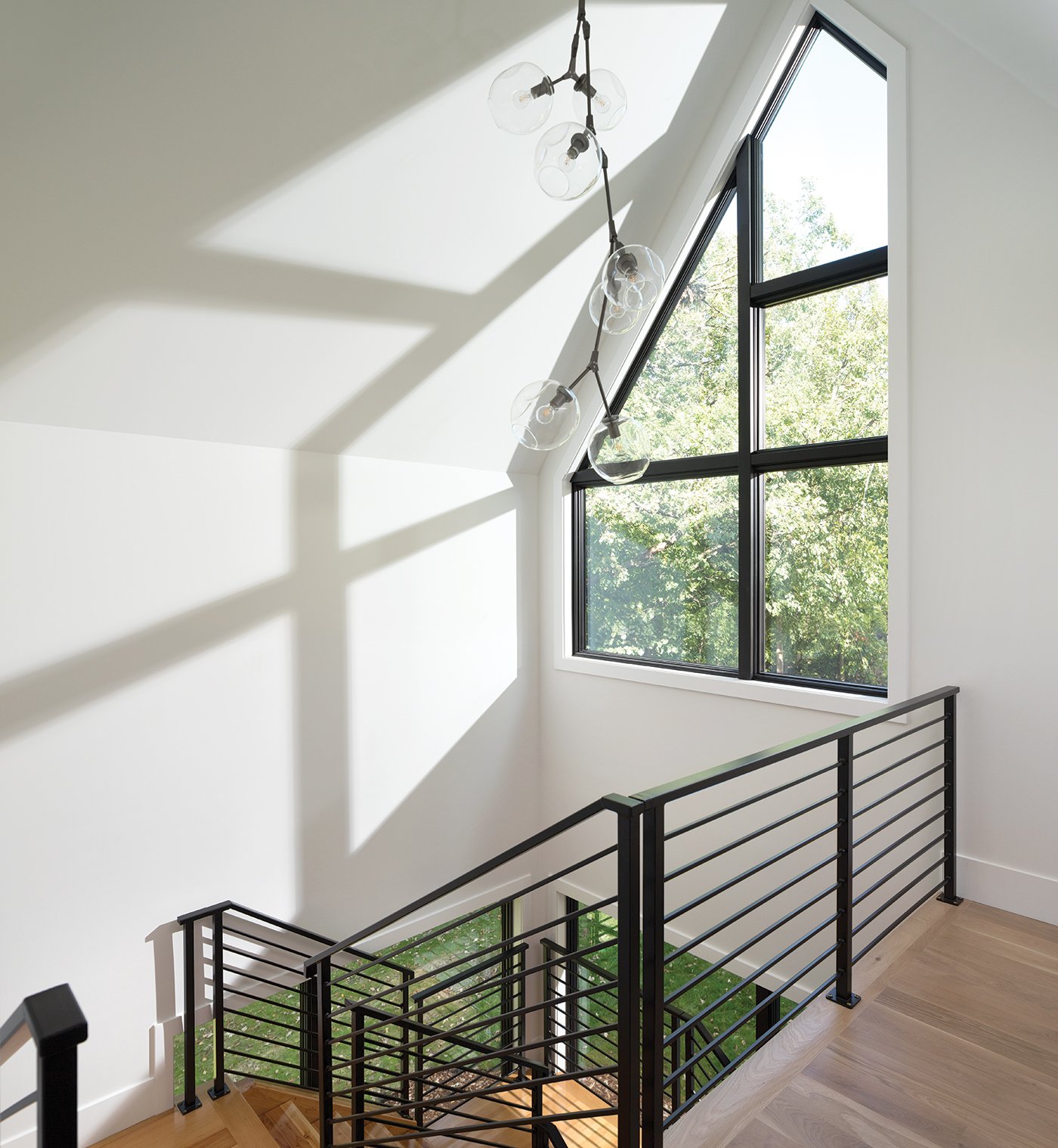 A staircase with a large Andersen® 400 Series Specialty Window combination.