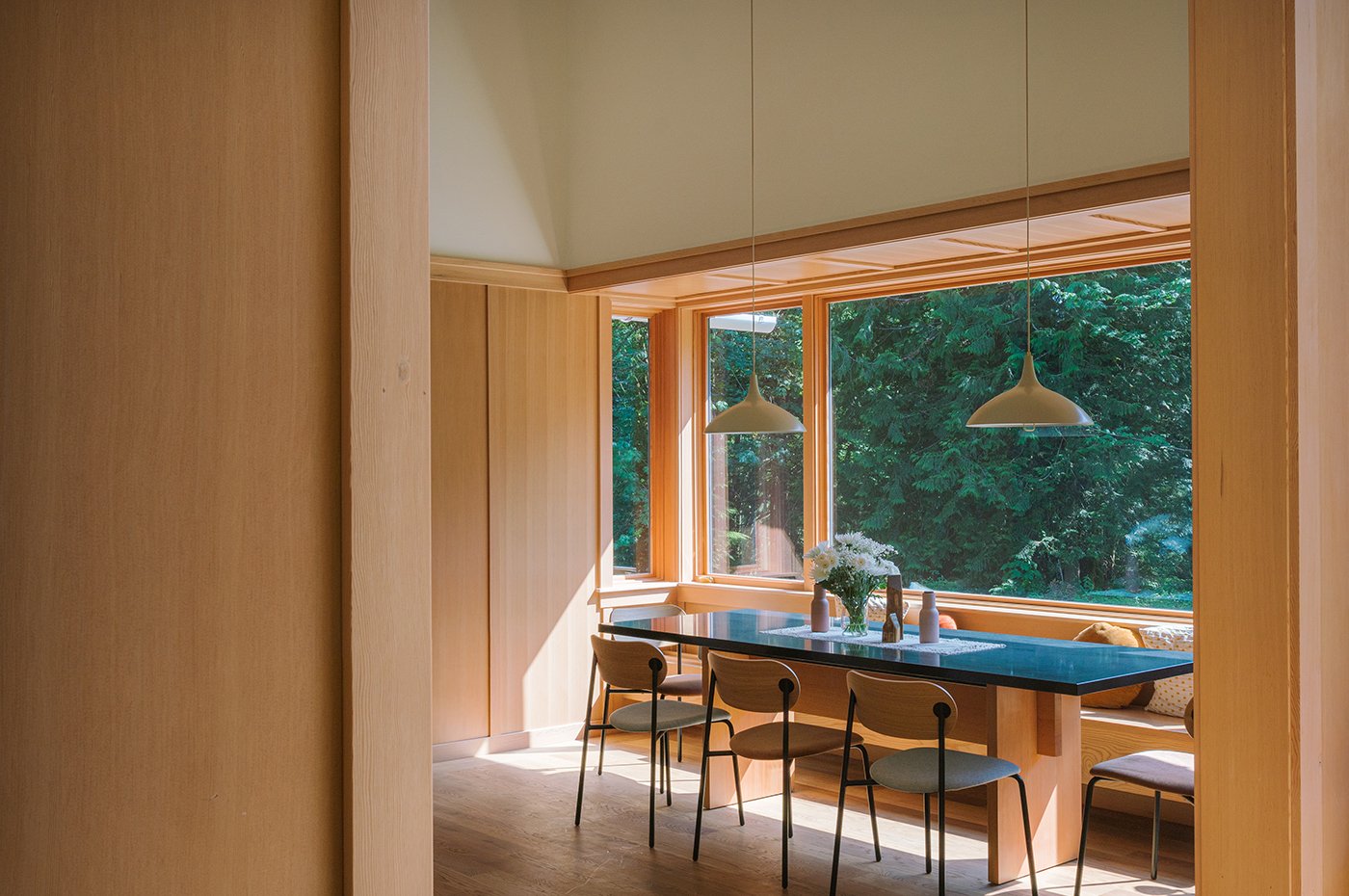 A breakfast nook that’s set inside a massive bay window composed of Andersen® E-Series windows