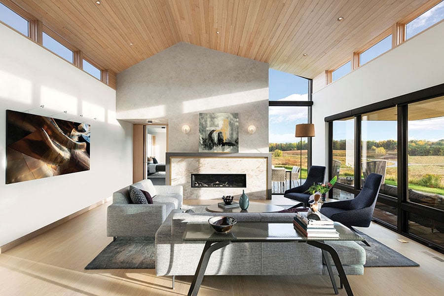 A living room with a wood ceiling, floor-to-ceiling windows along one wall, and clerestory windows on opposing walls.