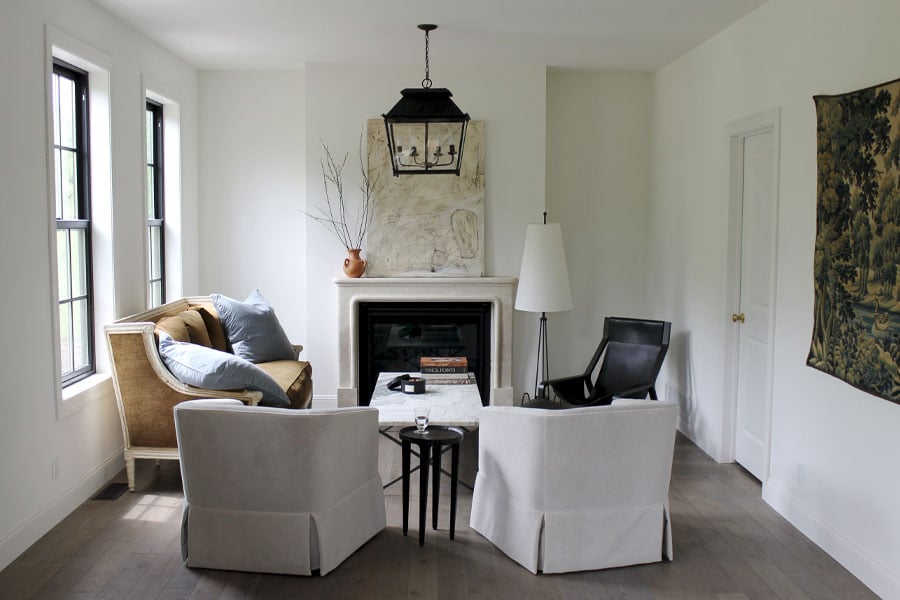 A limestone fireplace and lantern-style light fixture are the central elements in this European farmhouse living room.
