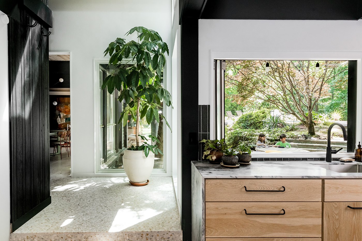 A Mid-century Modern home with a kitchenette featuring a Folding Pass-Through Window above the sink.