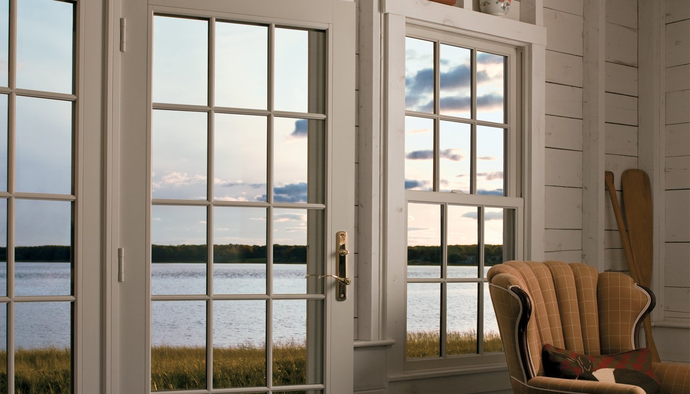 A cottage with water views through the 400 Series Hinged Patio Door with a transom above.