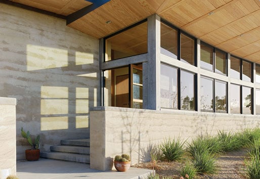 Two views of the home’s entrance, which features a Pivot Door with a clerestory window above.