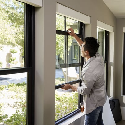 Man opening hung window